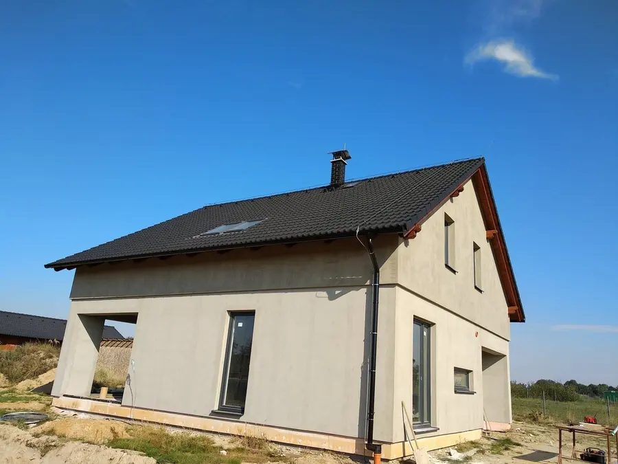 Hotový dům se šedou omítkou a&nbsp;tmavou střechou, Hřibiny