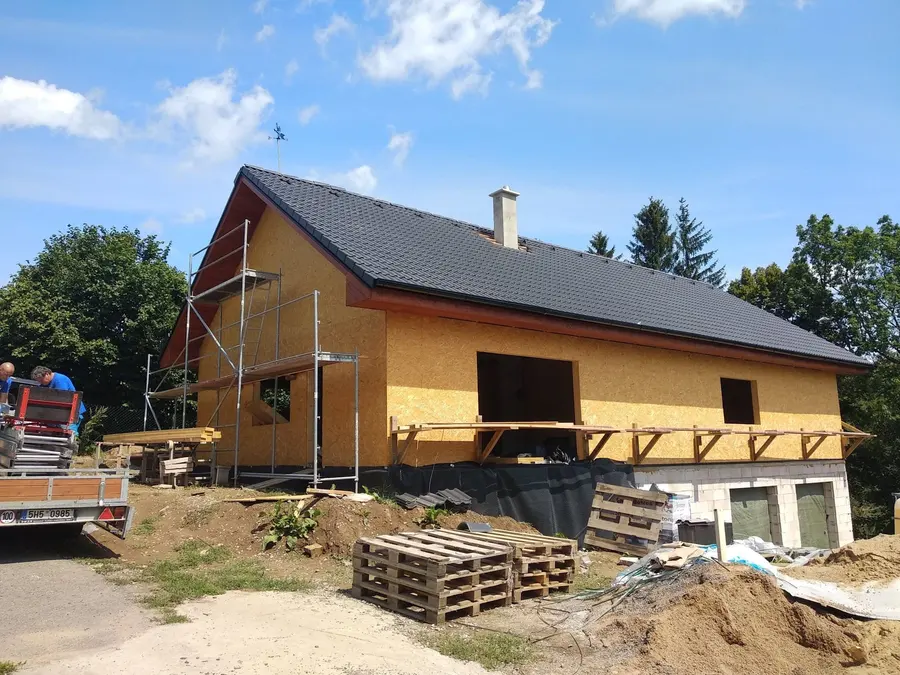 Hrubá stavba s&nbsp;hotovou tmavou taškovou střechou, Rokytnice v&nbsp;Orlických horách